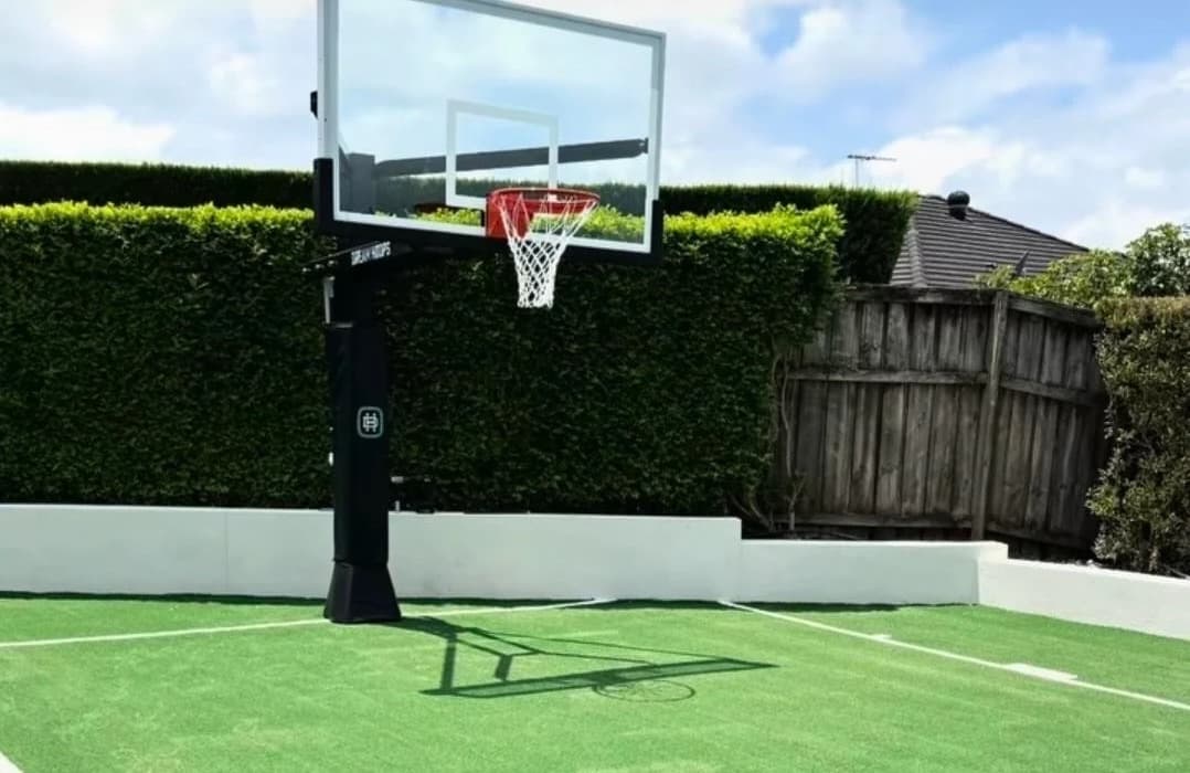 Backyard basketball hoop and court lines on artificial sports turf